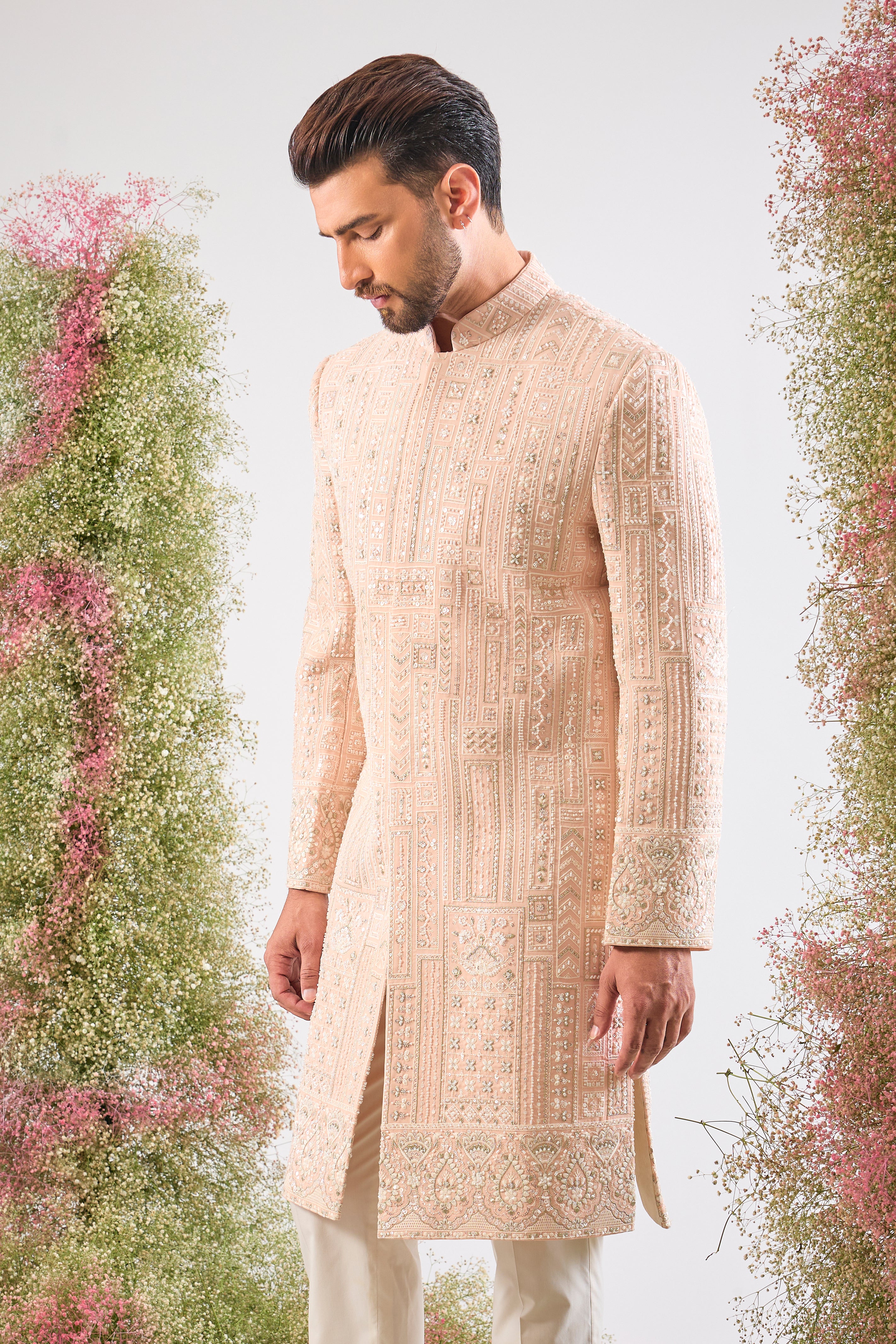 This Pink Sherwani showcases beautiful Geometrical Embroidery, with every line and angle accentuated by dazzling Cut Dana, reflective Sequins, and rich Zari Touches.