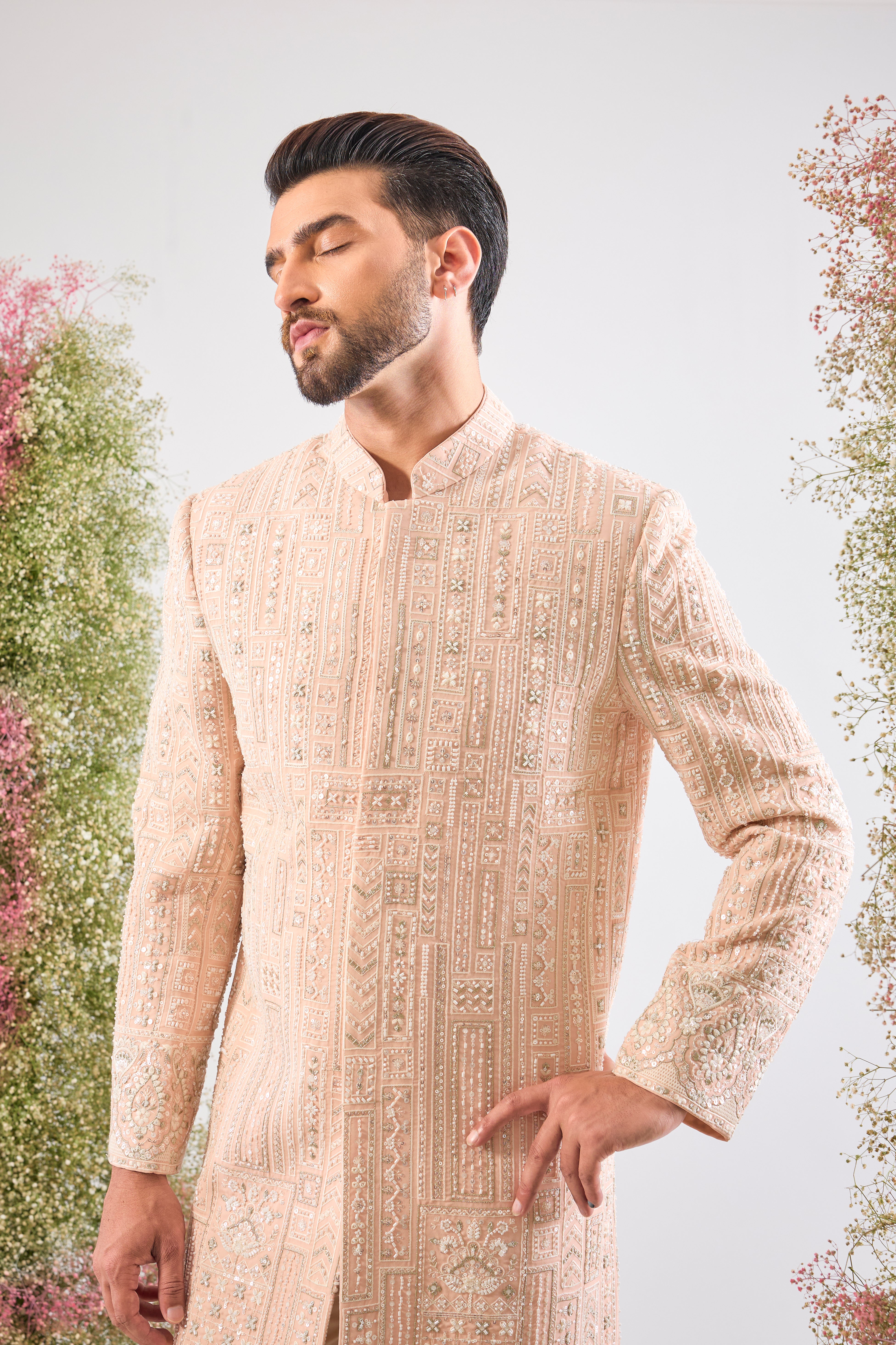 This Pink Sherwani showcases beautiful Geometrical Embroidery, with every line and angle accentuated by dazzling Cut Dana, reflective Sequins, and rich Zari Touches.