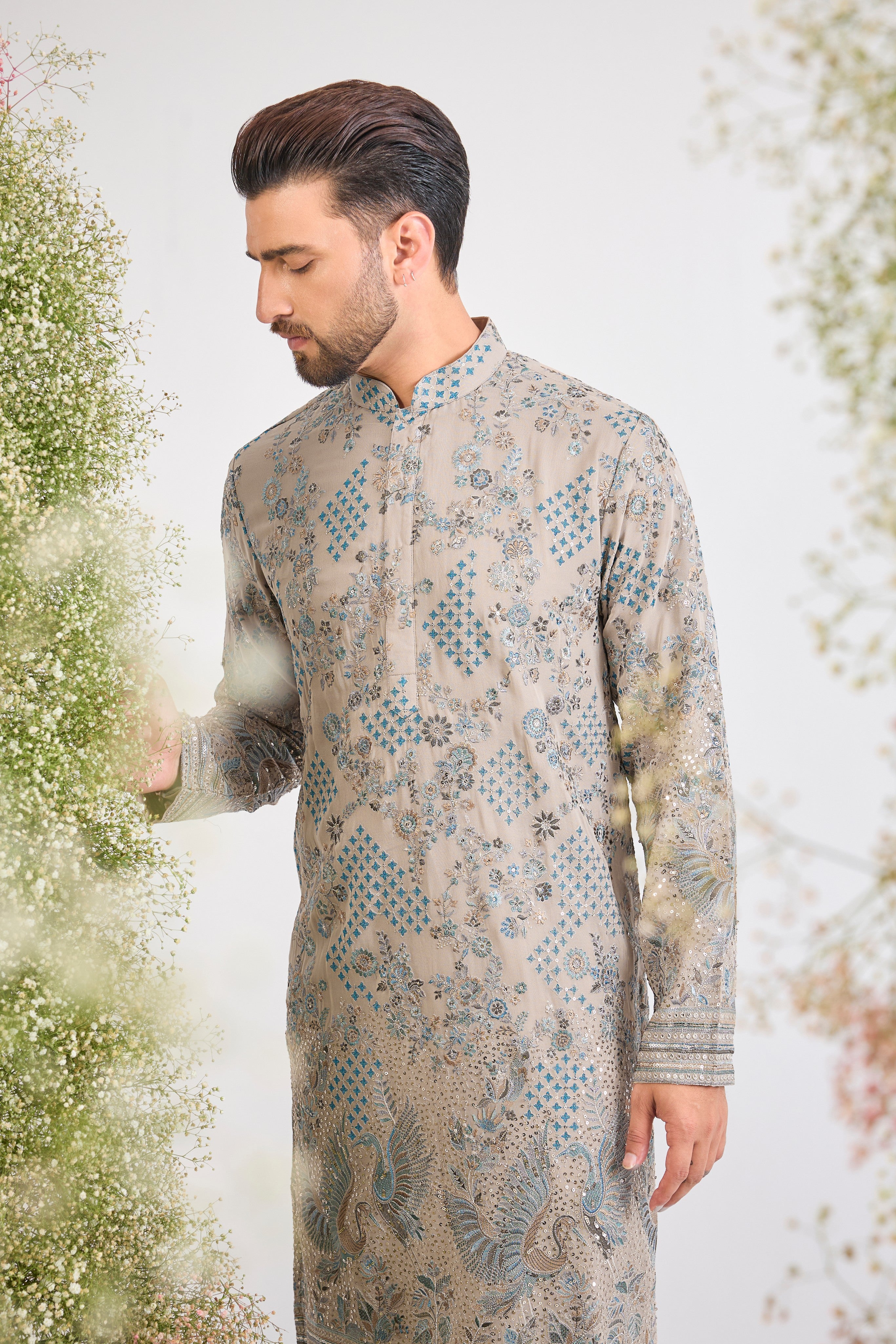 This Nude Coloured Long Kurta showcases magnificent Detailed Flora and Fauna Embroidery, executed with vibrant Multi-thread Work.