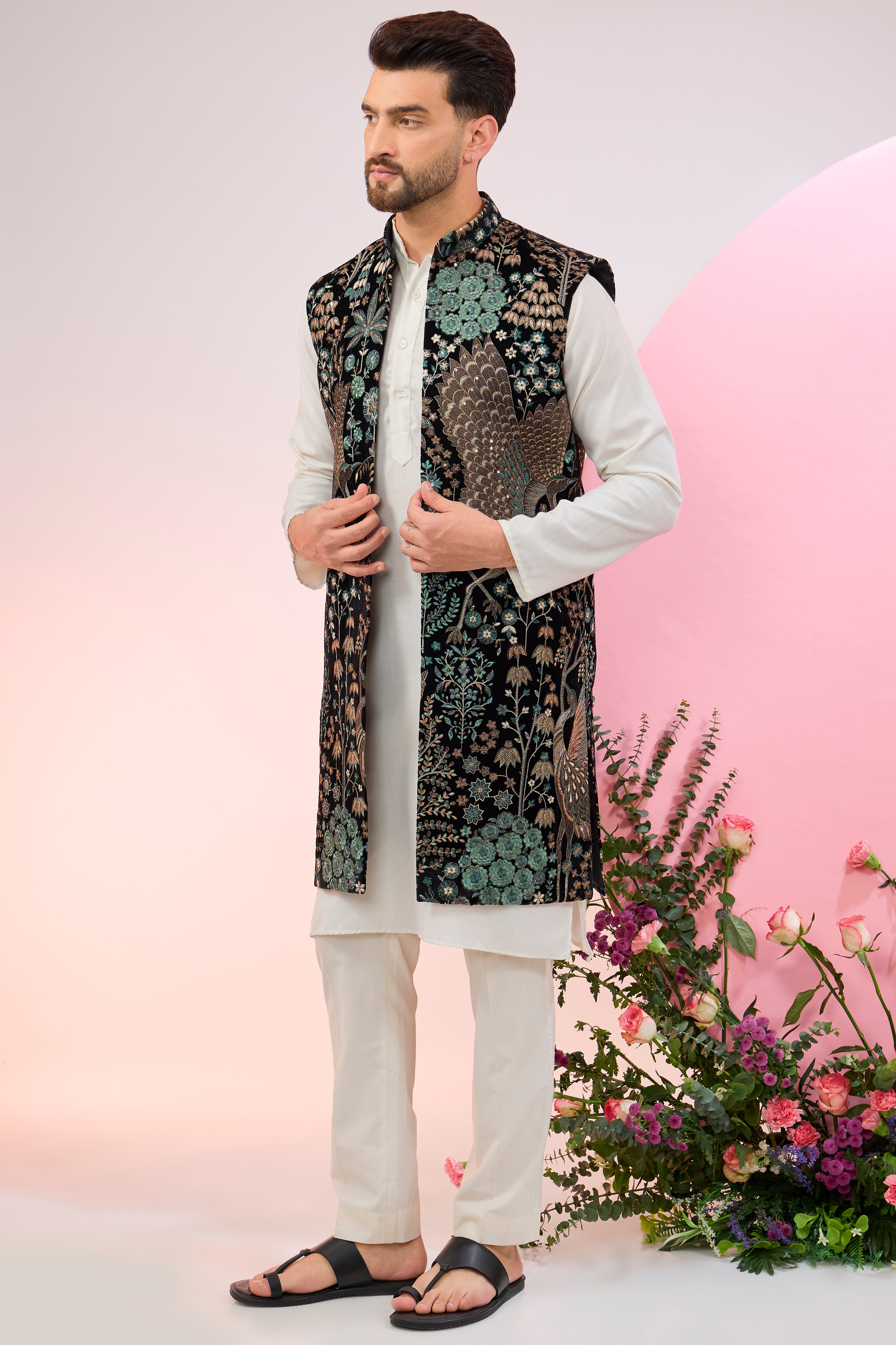 Black long jacket on velvet with intricate flora and fauna embroidery.