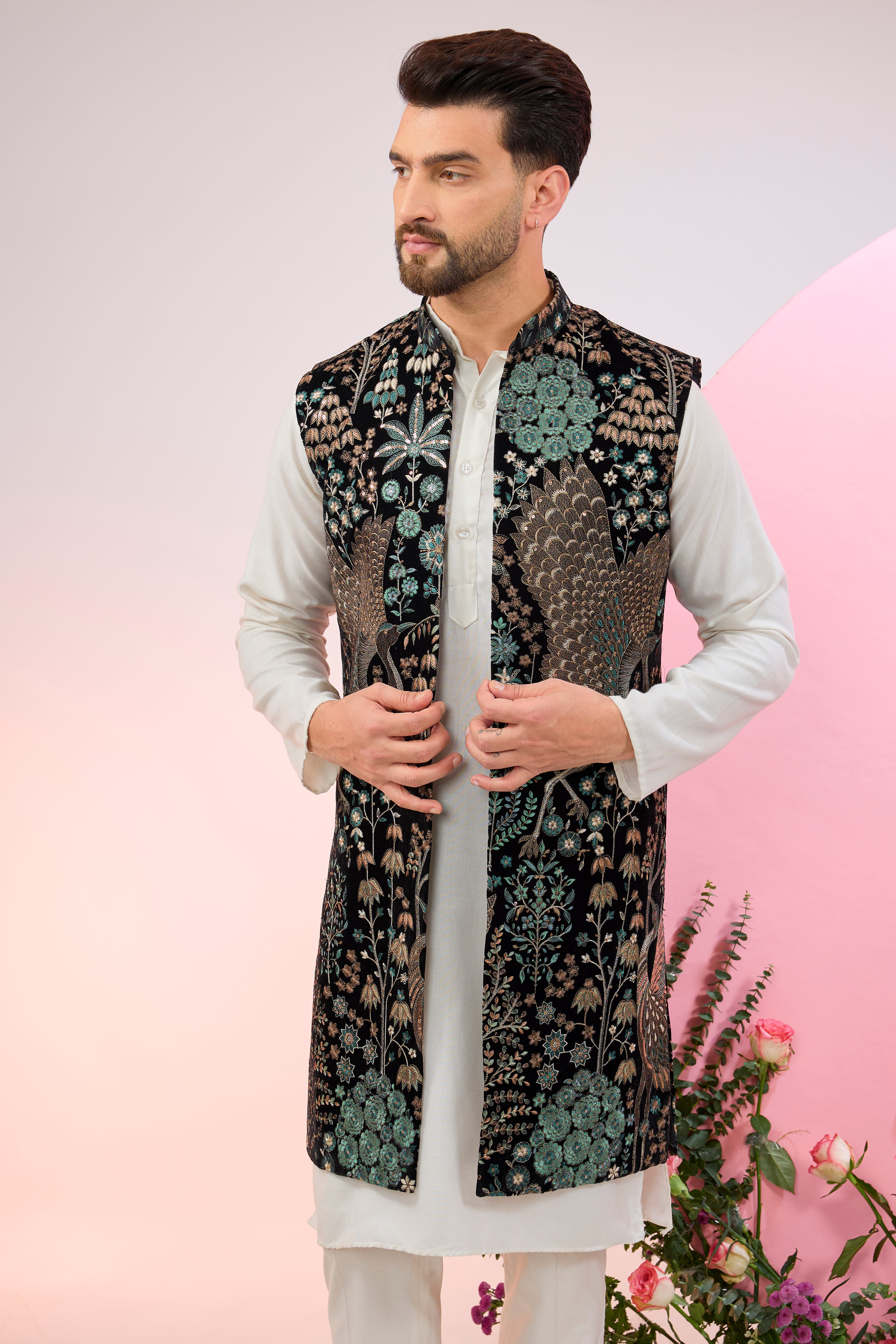 Black long jacket on velvet with intricate flora and fauna embroidery.